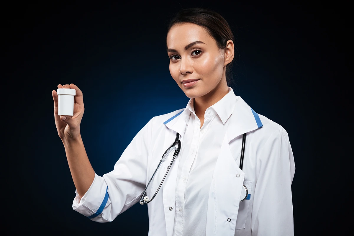 young brunette female nurse showing bottle with pills isolated